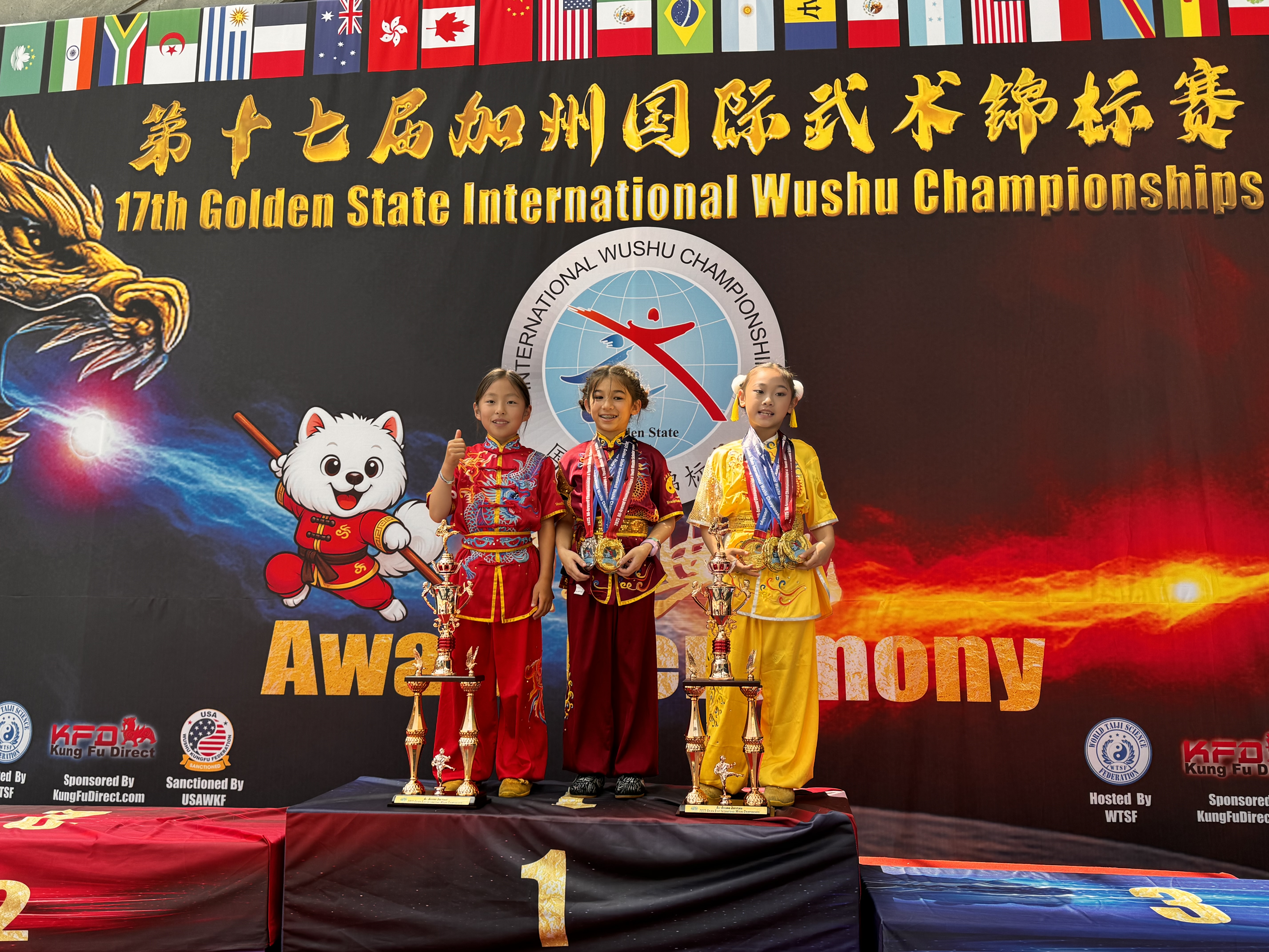 Three students holding medals on competition podium