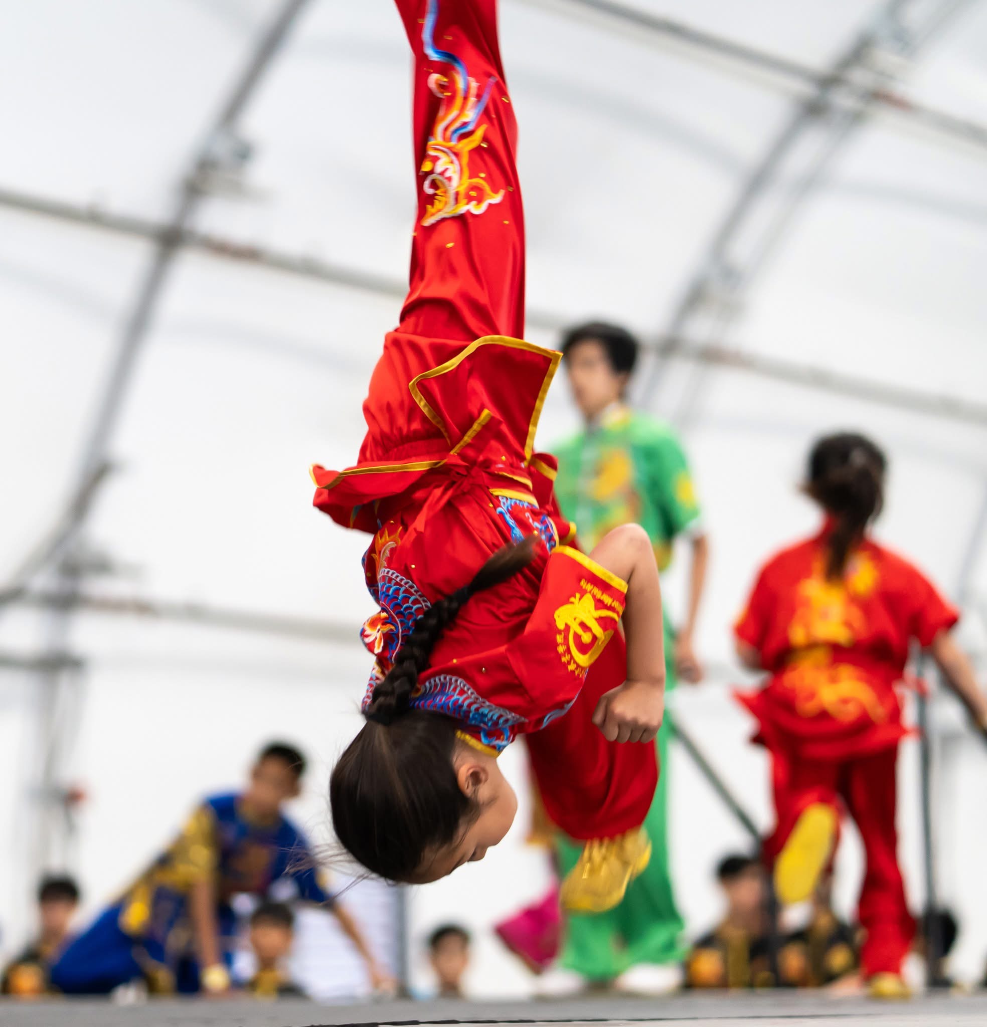 Student performing aerial backflip in competition