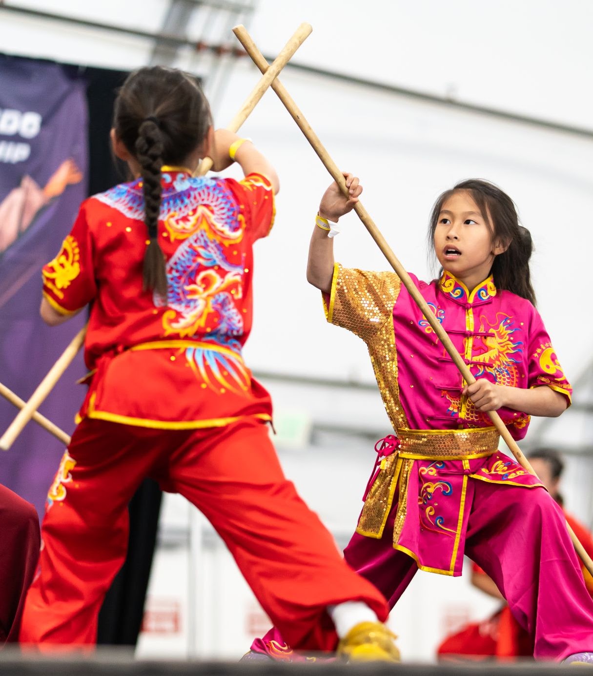Two students performing partner staff set at competition