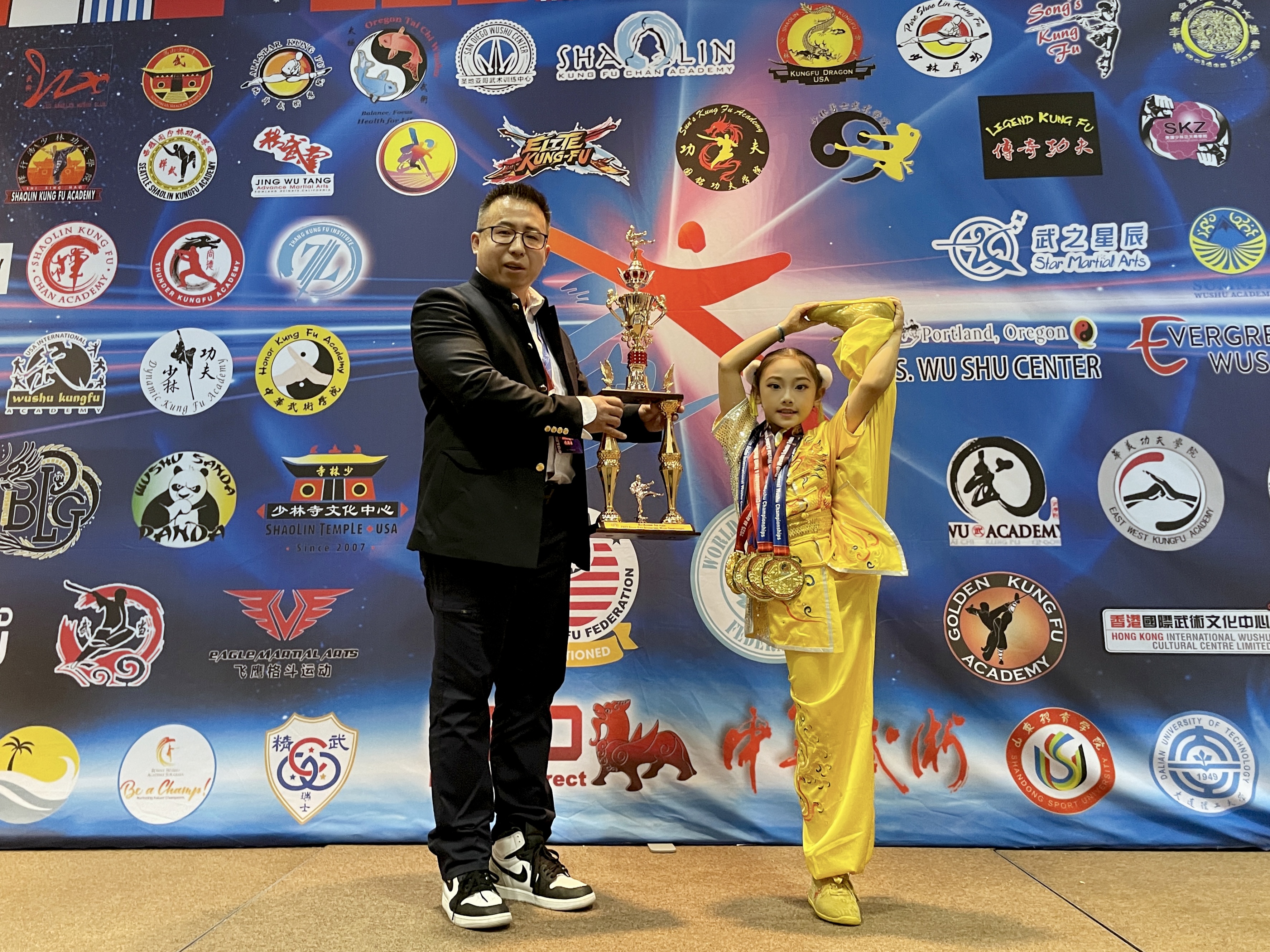 Young student receiving grand champion trophy from instructor